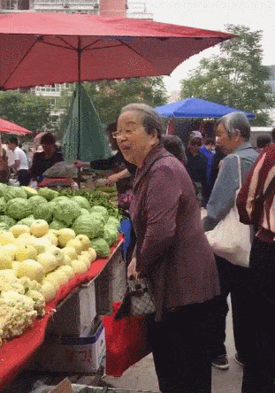 83岁李明启背名牌包市场买菜，身体硬朗和小贩热聊如寻常老太