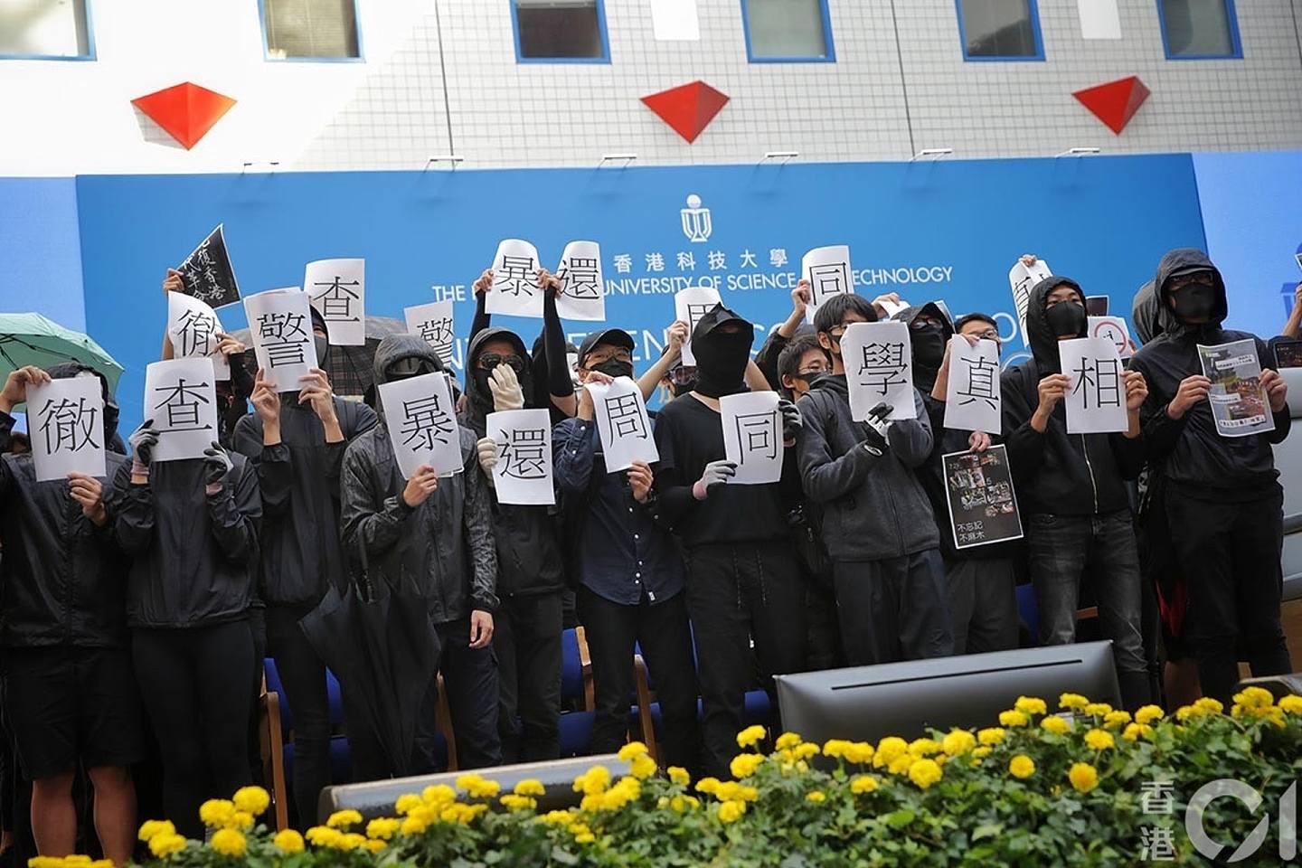11月7日科大毕业礼，有学生一度冲上主礼台，展示要求彻查警暴、还原周同学真相的表语。 学生十分钟内离开。 （李泽彤摄）