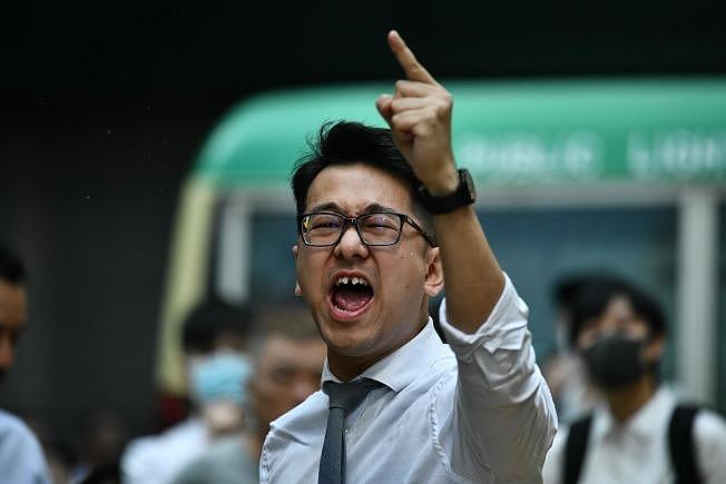 一名香港警察11日开枪射伤一名黑衣示威者，引发众怒；图为一位民众对着警察斥骂。 (Getty Images)