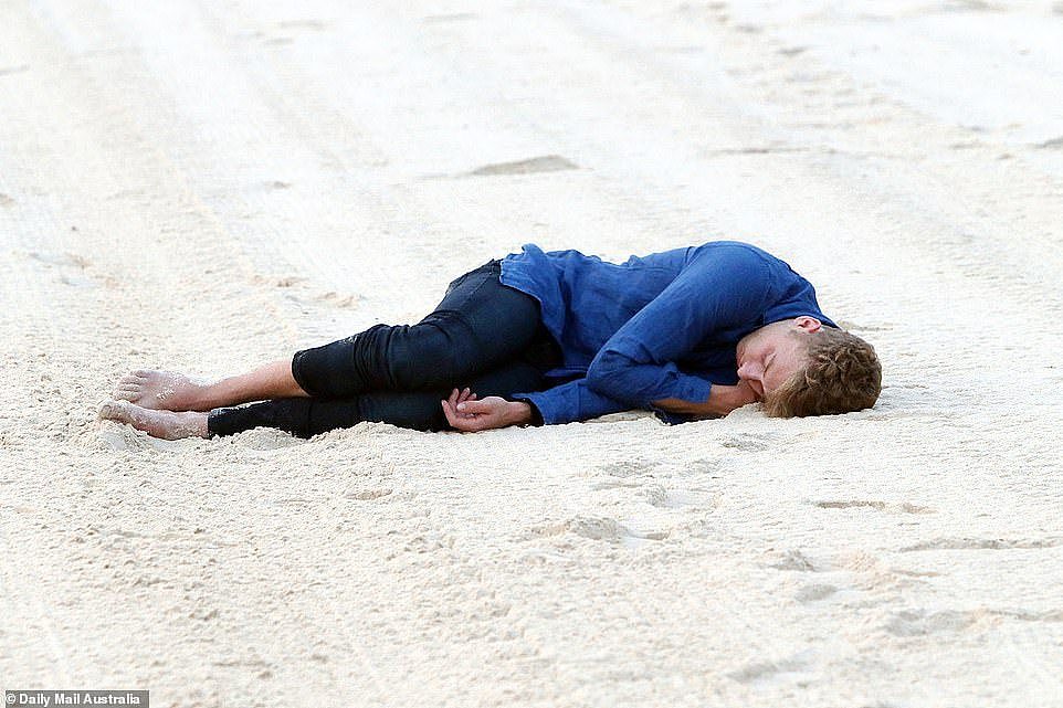 Sleepy head: One young man was photographed in the early hours of Sunday morning sleeping on the beach