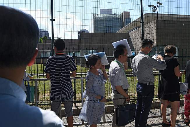 统计显示，美中贸易战以来，中国公民获美签证剧减。 图为大批民众在北京美国大使馆前排队等候申请签证。 (Getty Images)