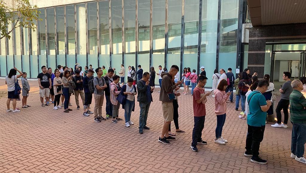 在香港荃湾某票站门前，选民一早已经在票站外排队投票，情况之踊跃乃过去罕见，而且投票者又以年轻选民居多。