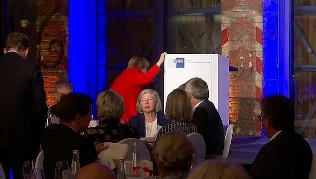 德国总理默克尔在登台演讲时失去平衡，差点趴倒在地