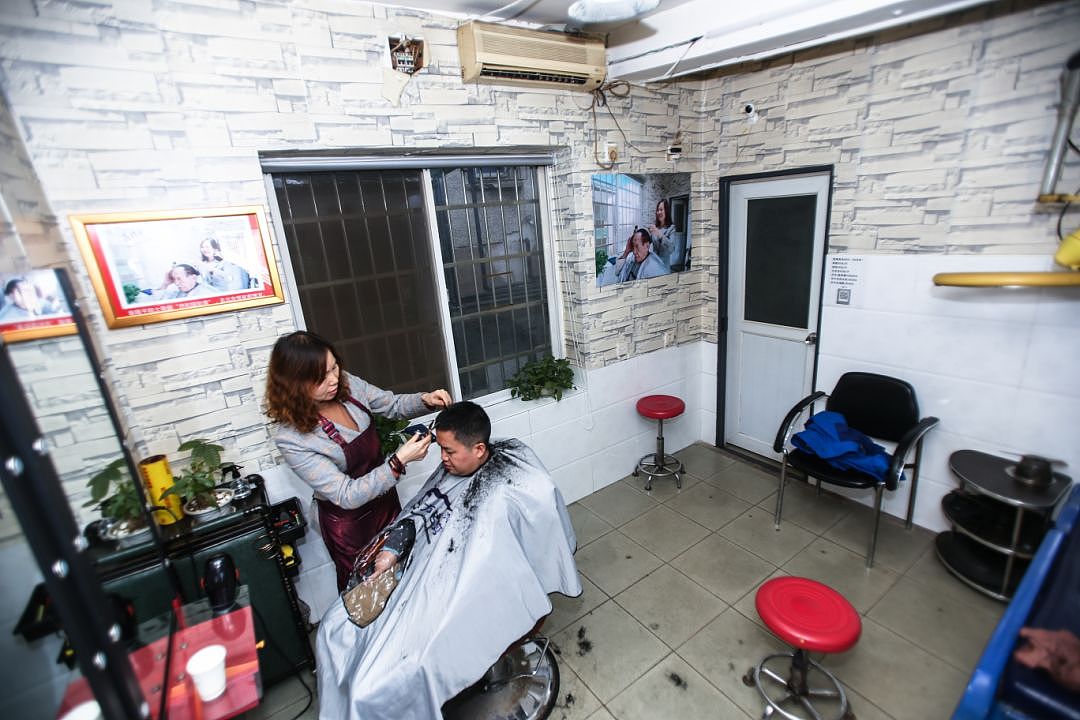 12月10日，位于红园东路的曹氏名剪理发店内，店主曹小平正在为顾客理发，作为袁隆平院士十几年的指定理发店仅仅只有几平方米大小，很难容得下较多的顾客。图 记者/张云峰