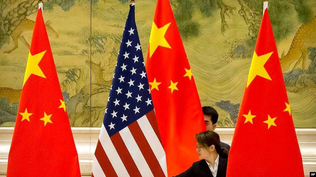 资料照片： 在北京钓鱼台国宾馆，中方工作人员在美中贸易谈判开始前摆放两国国旗.（2019年2月14日）