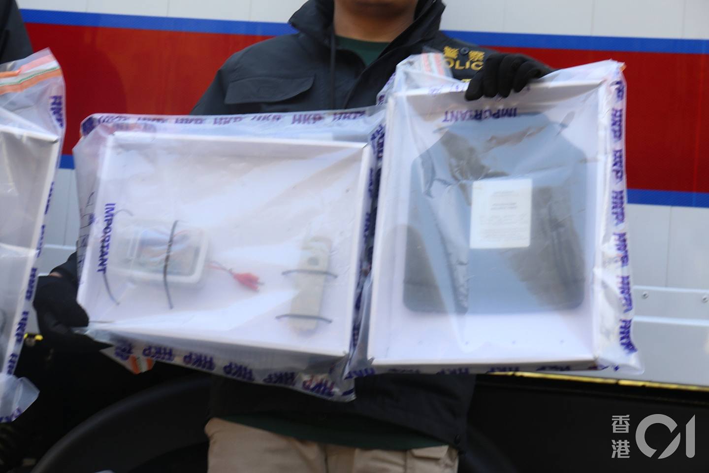 警方展示爆炸装置（左），分别是一个遥控及以胶盒装起的电线、电路板。 （陈浩然摄）