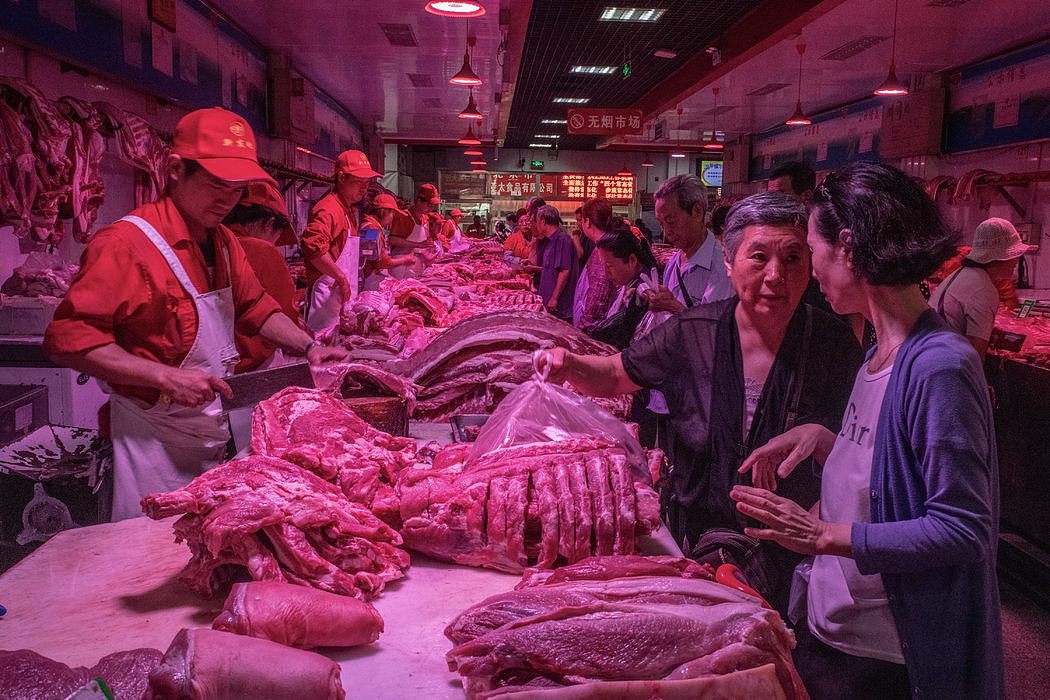 北京一个猪肉批发市场的买家和卖家。