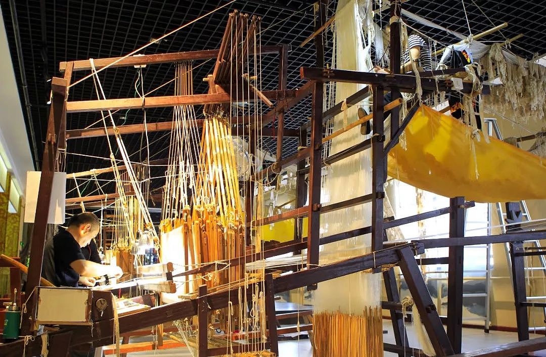 ▲江苏南京市云锦博物馆，两名织工在织机上配合编织云锦。（新华社）