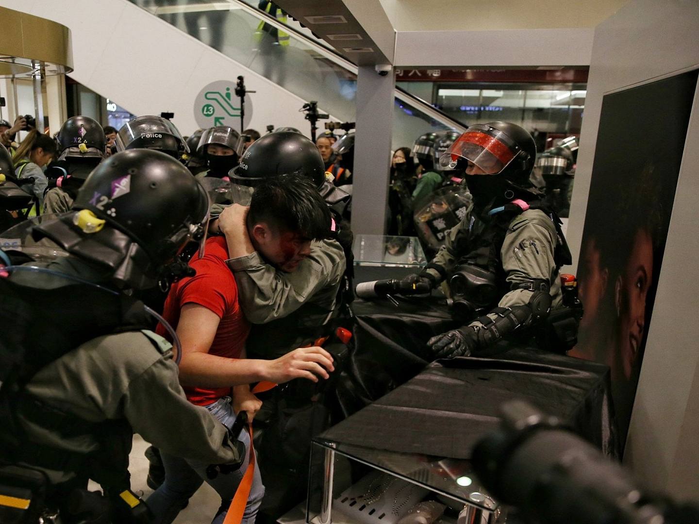 一名红衣男子被警方制服期间涉嫌袭警及企图抢夺警员配枪。（HK01）