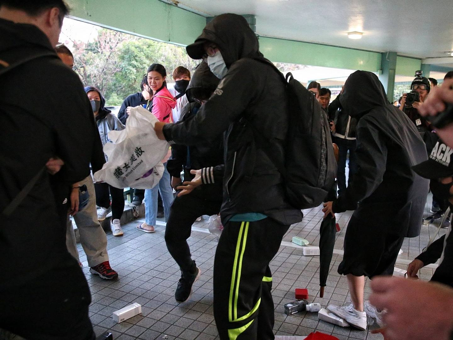 激进示威者抢夺疑似内地旅客购买的商品。（HK01）
