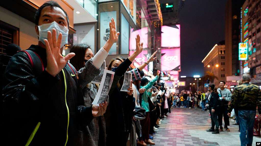 香港抗议者在新年除夕夜组成人链，伸出手掌表示“五项诉求，缺一不可”。（2019年12月31日）