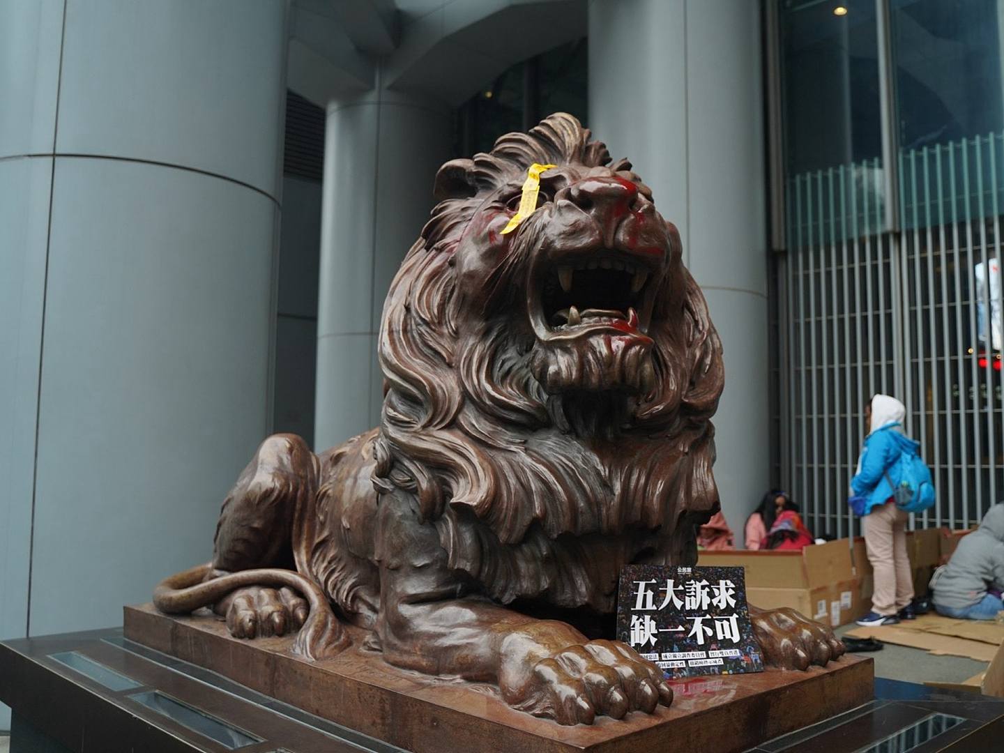汇丰银行狮子像被喷红漆并贴上标语。（HK01）