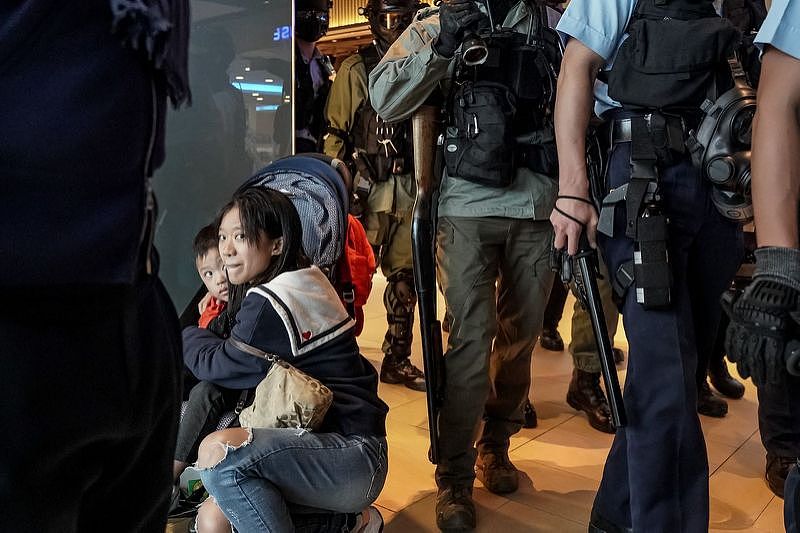 香港沙田区新城市广场的示威活动中，一名女子在警察经过时护着孩子。 图片来源：ANTHONY KWAN FOR THE WALL STREET JOURNA