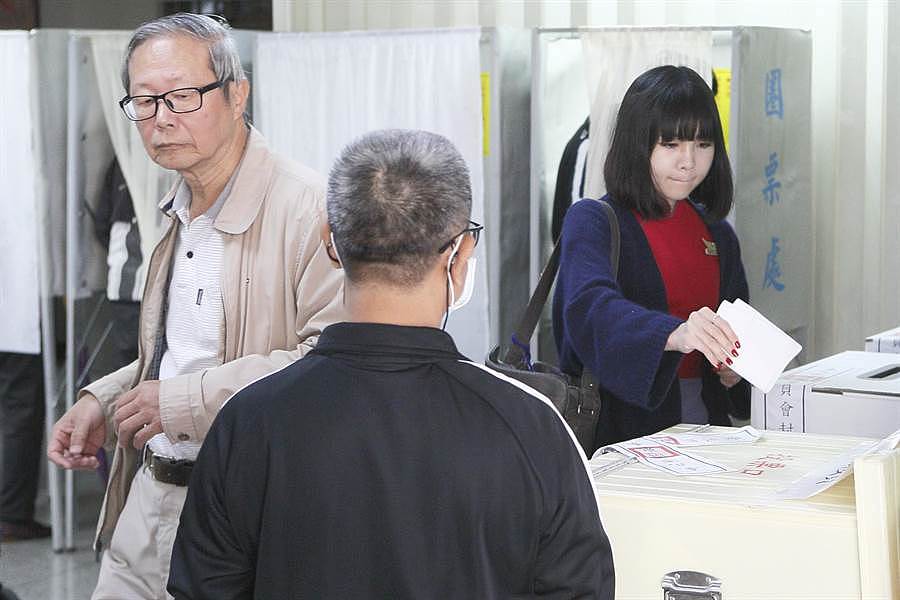 图为在台北市北投福星宫投开票所，有位中华航空空姐穿着制服，赶在上班前投下神圣的一票。（张铠乙摄）