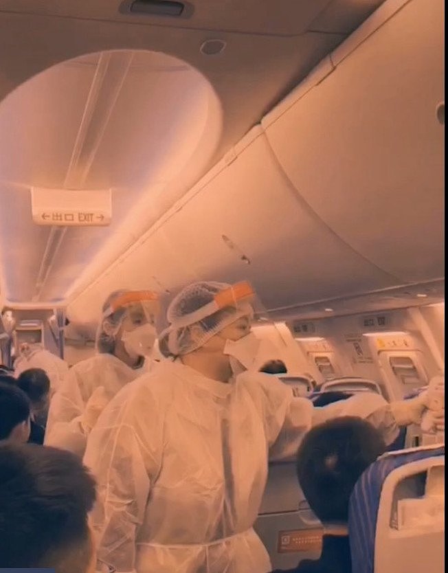 网传自武汉飞出的航班上，都有穿着防疫装的医务人员检查离境旅客的体温。 (截自视频)