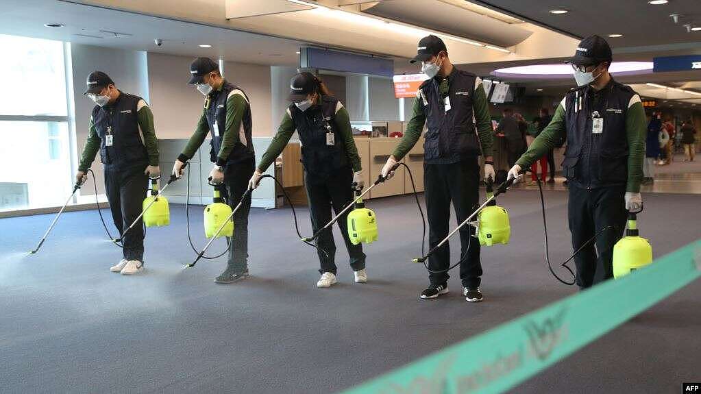 韩国首尔以西的仁川国际机场，清洁服务人员在海关、移民和检疫区喷洒消毒剂（2020年1月21日）。