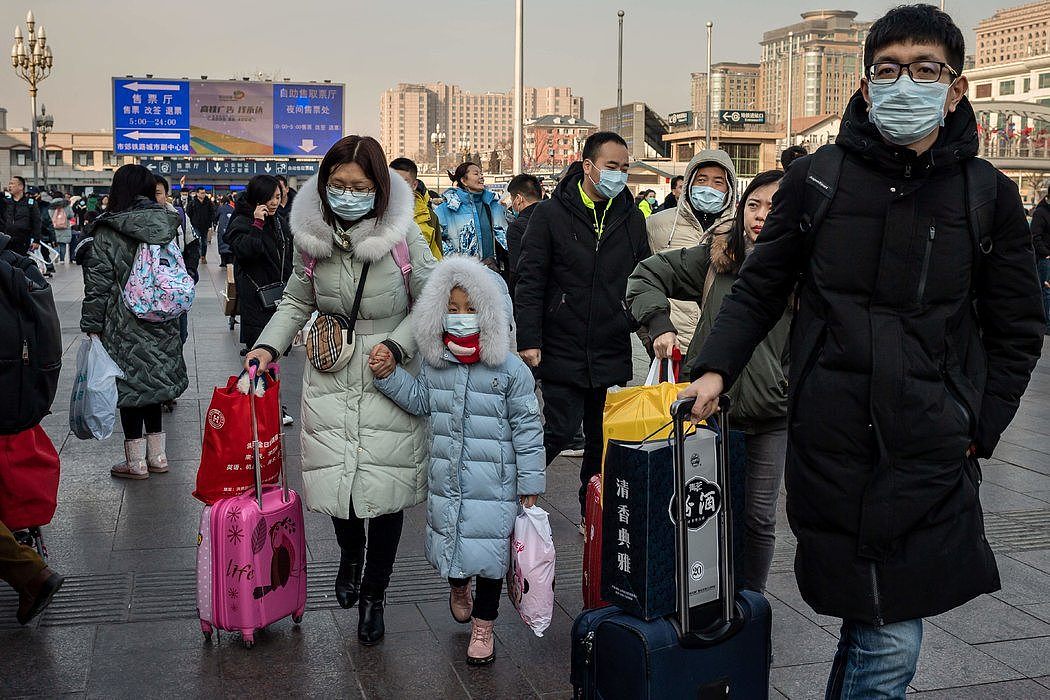 周二，北京主要火车站的旅客戴上了防护口罩。