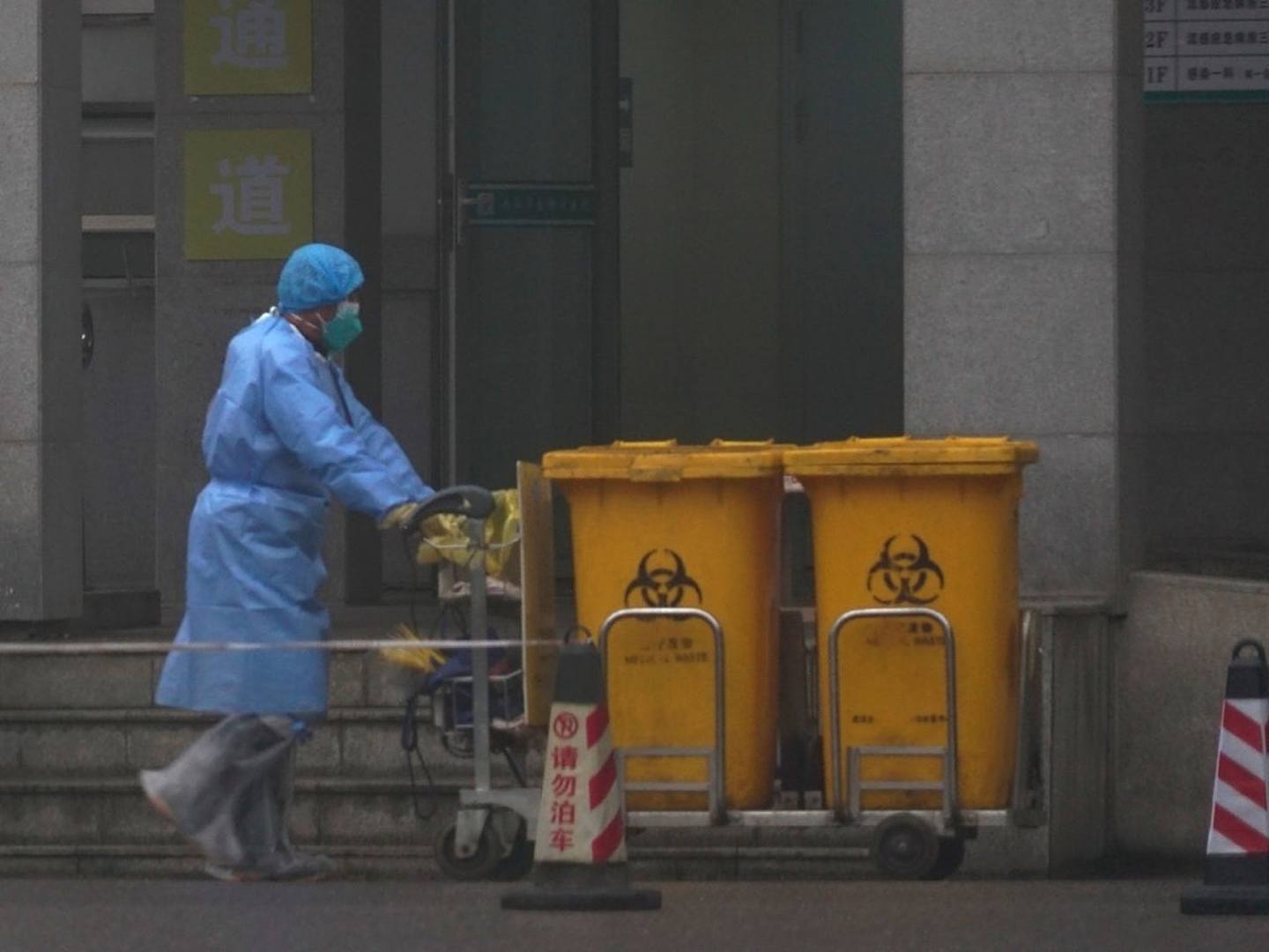 1月22日，工作人员将生物废料容器移过武汉医疗救助中心的入口，一些感染了一种新病毒的患者正在这里接受治疗。（AP）