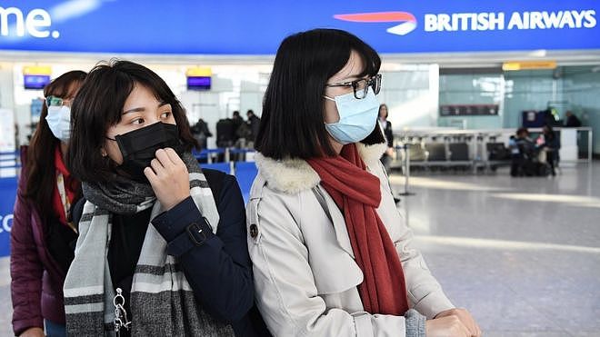 抵达伦敦希斯罗机场的乘客戴着口罩