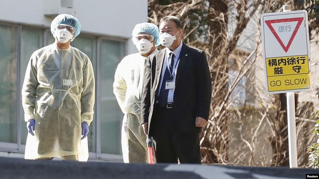 日本卫生官员戴着防疫口罩在东京的国立国际医疗研究中心等候从武汉撤回国的日本侨民。（2020年1月30日）
