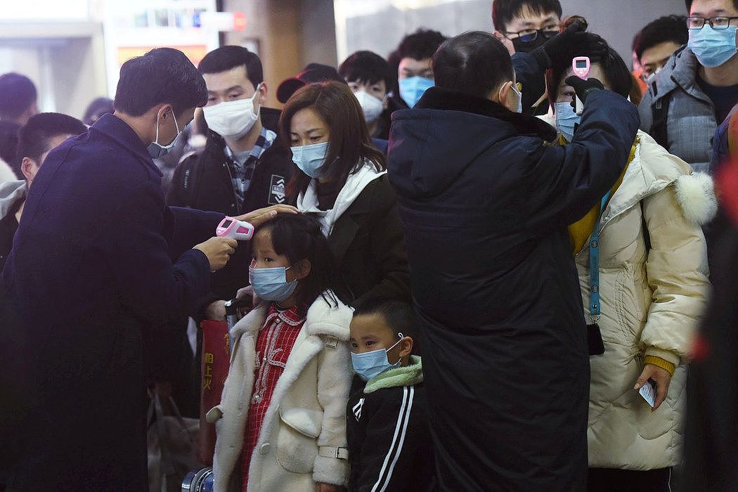 1月23日，杭州的卫生官员为从武汉来的火车乘客量体温。