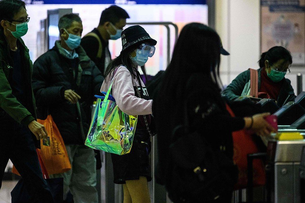 周一，到达香港的旅客戴着防护口罩。