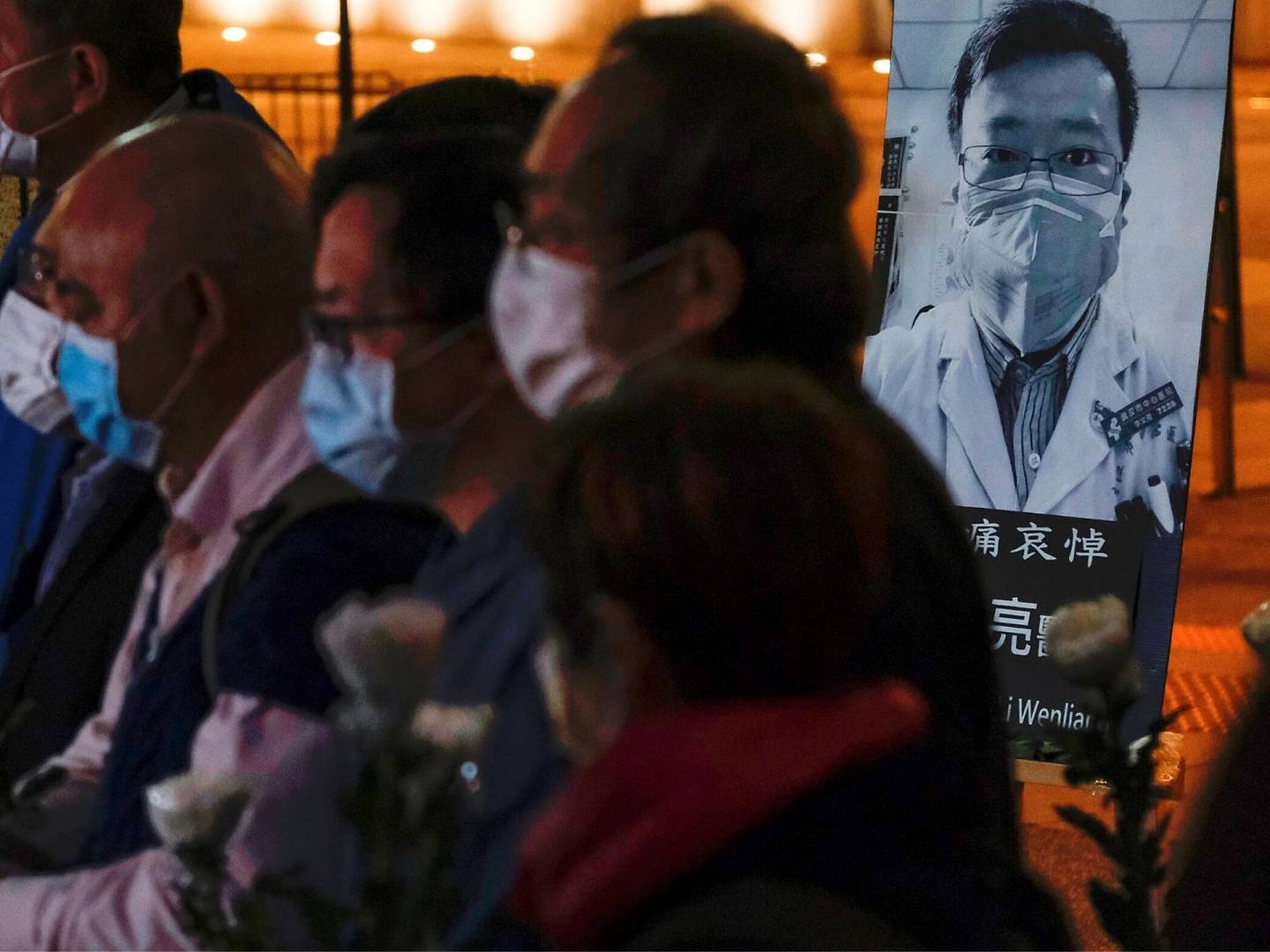 戴着口罩的人们参加了为已故眼科医生李文亮举行的守夜仪式。（Reuters）