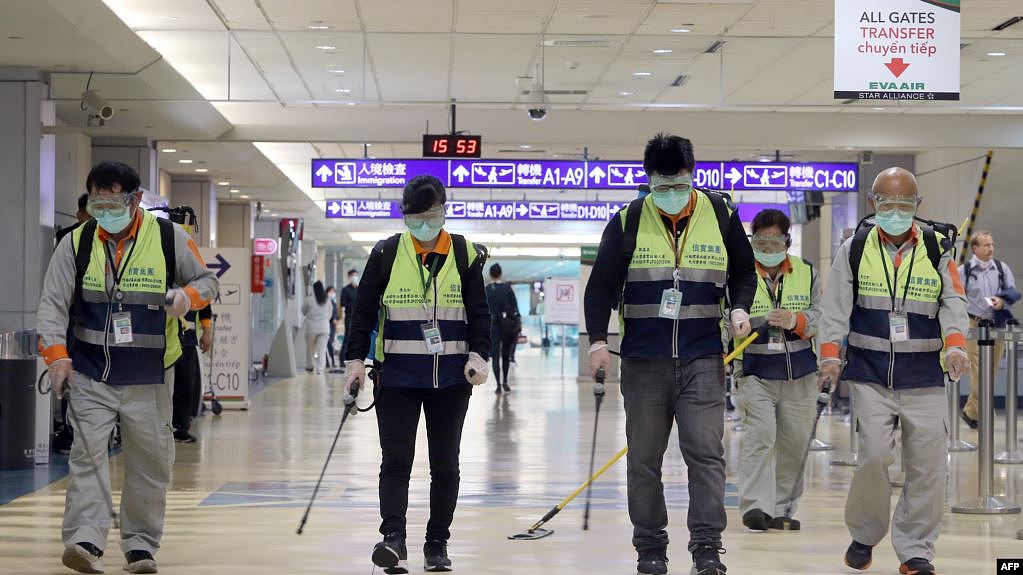 戴着口罩的工作人员在台北桃园机场喷洒消毒药水防范新冠病毒。（2020年1月22日）