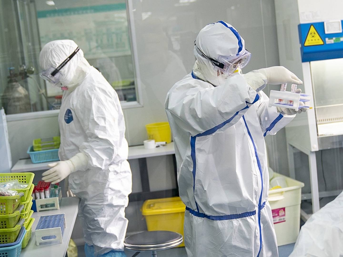 武汉金域医学公司核酸检测实验室的工作人员2月13日在对病人样本进行核酸检测，新型冠状病毒核酸的检测结果是目前确诊的重要参考。（新华社）