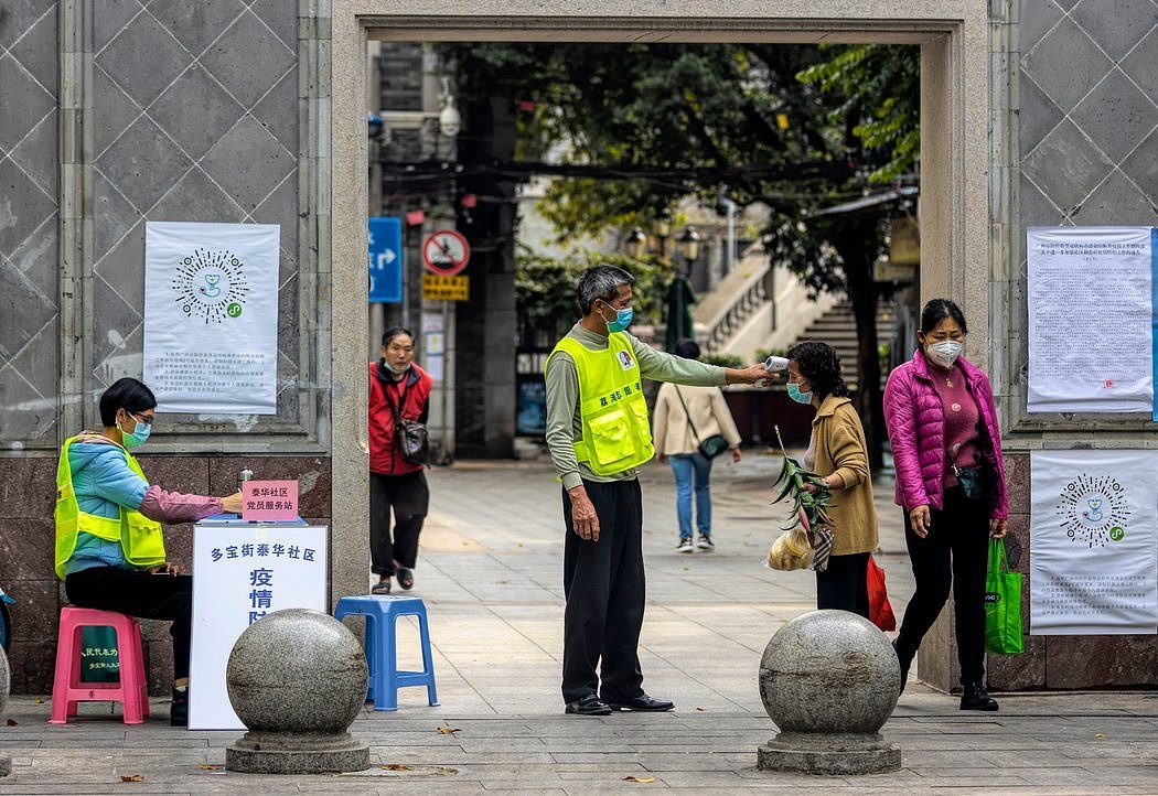 周四，卫生工作者在中国广州检查体温。