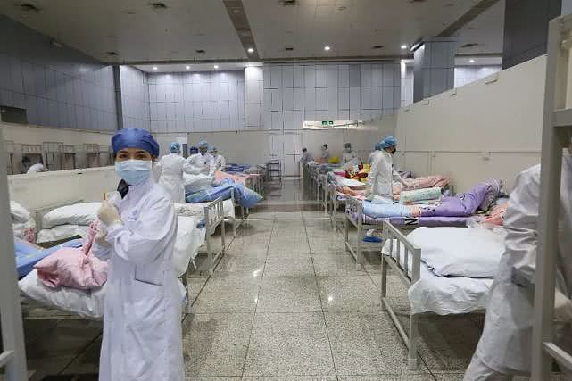2月5日，由武汉国际会展中心改造的方舱医院，医护人员在整理床位。摄影/《中国慈善家》记者 温如军