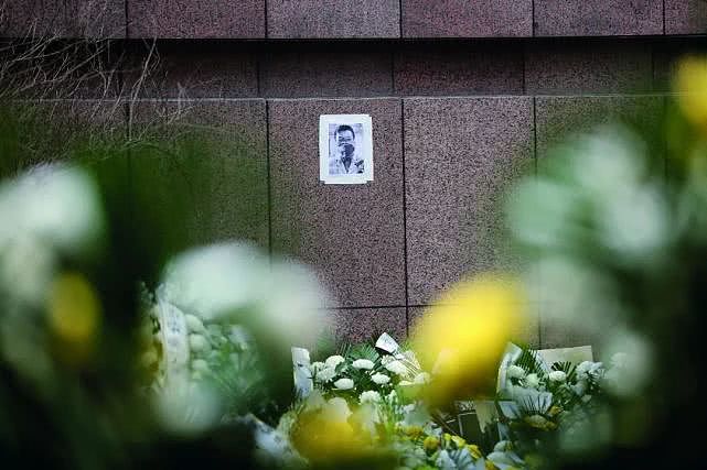 悼念者将李文亮的遗照贴在其生前工作过的院区，前面摆满了鲜花。摄影/《中国慈善家》记者  温如军