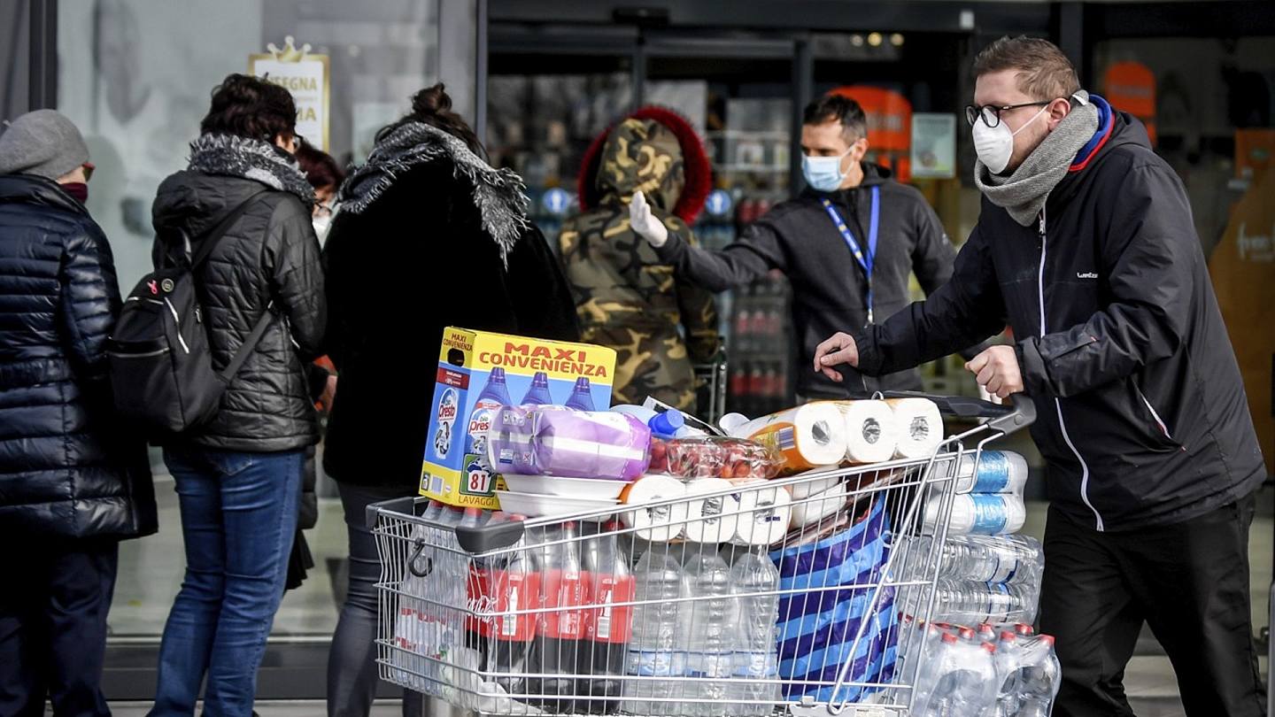 2月23日戴着卫生口罩的意大利人在北部卡萨尔普斯特伦戈的一家超市外面排队。（AP）