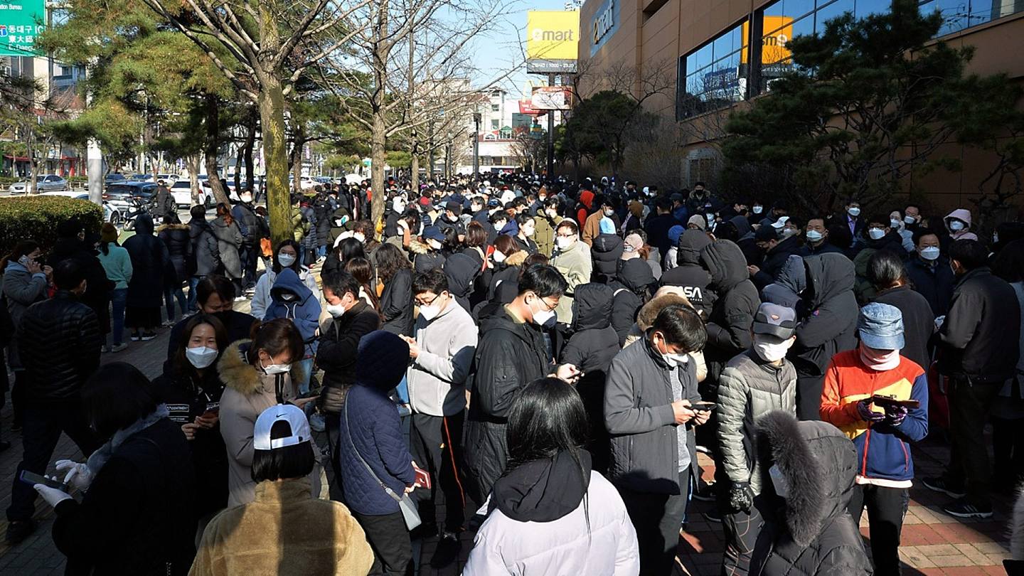 韩国宣布全国进入传染病最高警戒状态后，2月24日人们在韩国大邱的一家商店排队购买口罩。（AP）