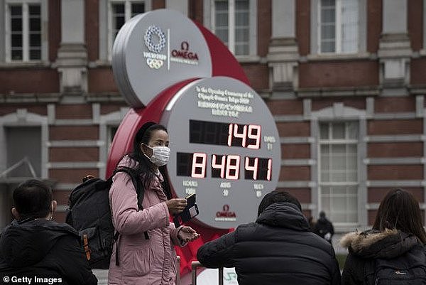 25255024-8049773-A_woman_wearing_a_face_mask_stands_in_front_of_the_countdown_clo-a-12_1582774163491.jpg,0
