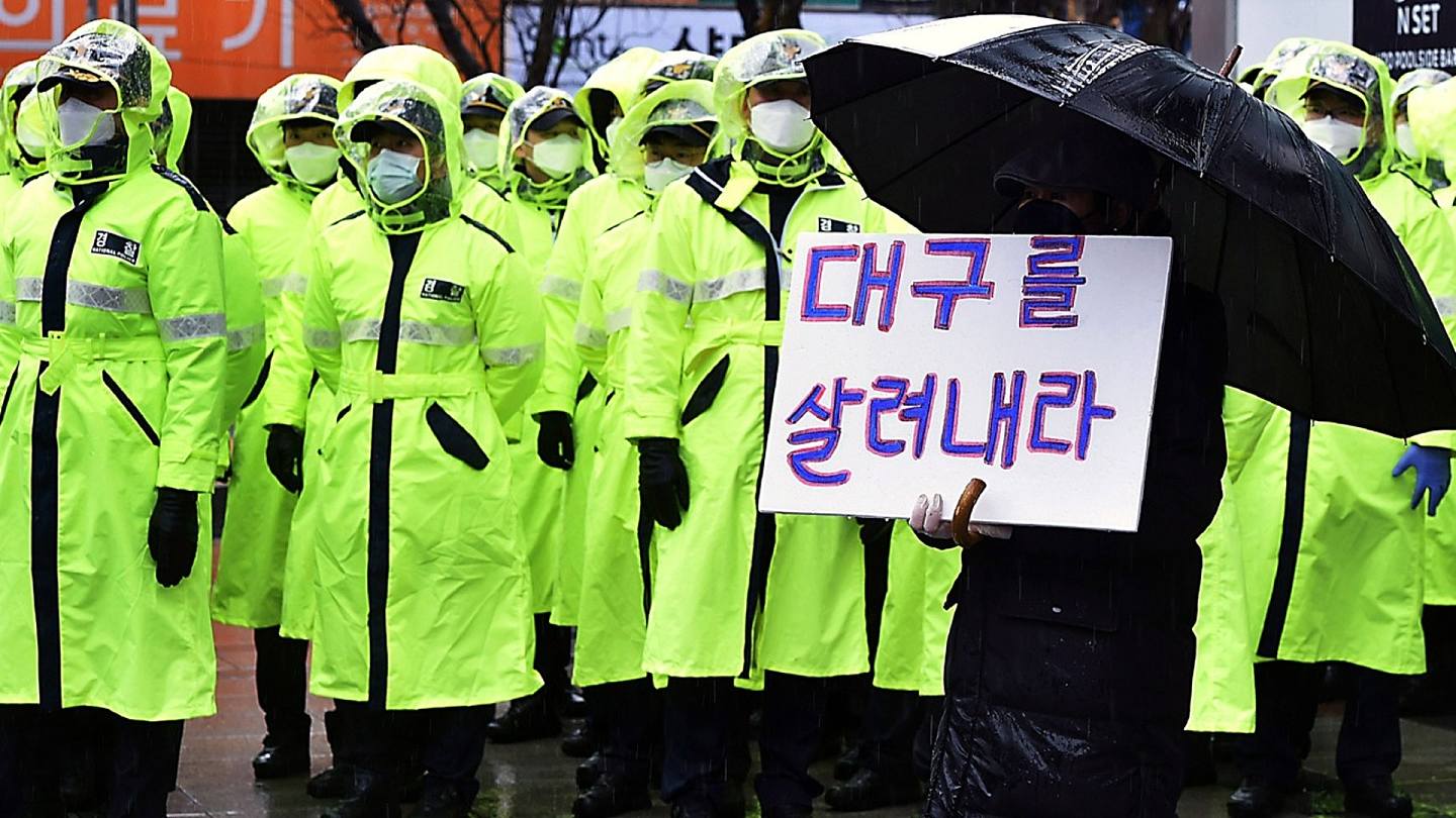 2月25日一名抗议者举着标语谴责政府对新冠病毒的应对措施，牌子上写着“救救大邱”。(AP)