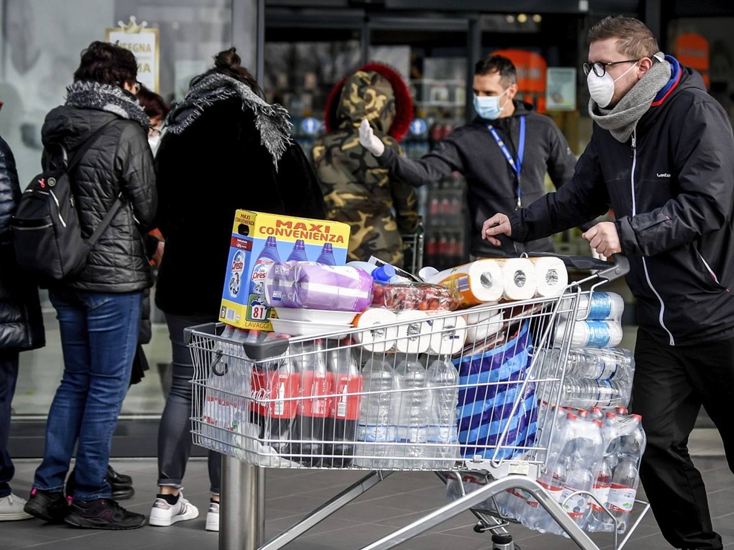2020年2月23日，戴着口罩的民众在意大利北部卡萨尔普斯特伦戈的一家超市外面排队。（AP）