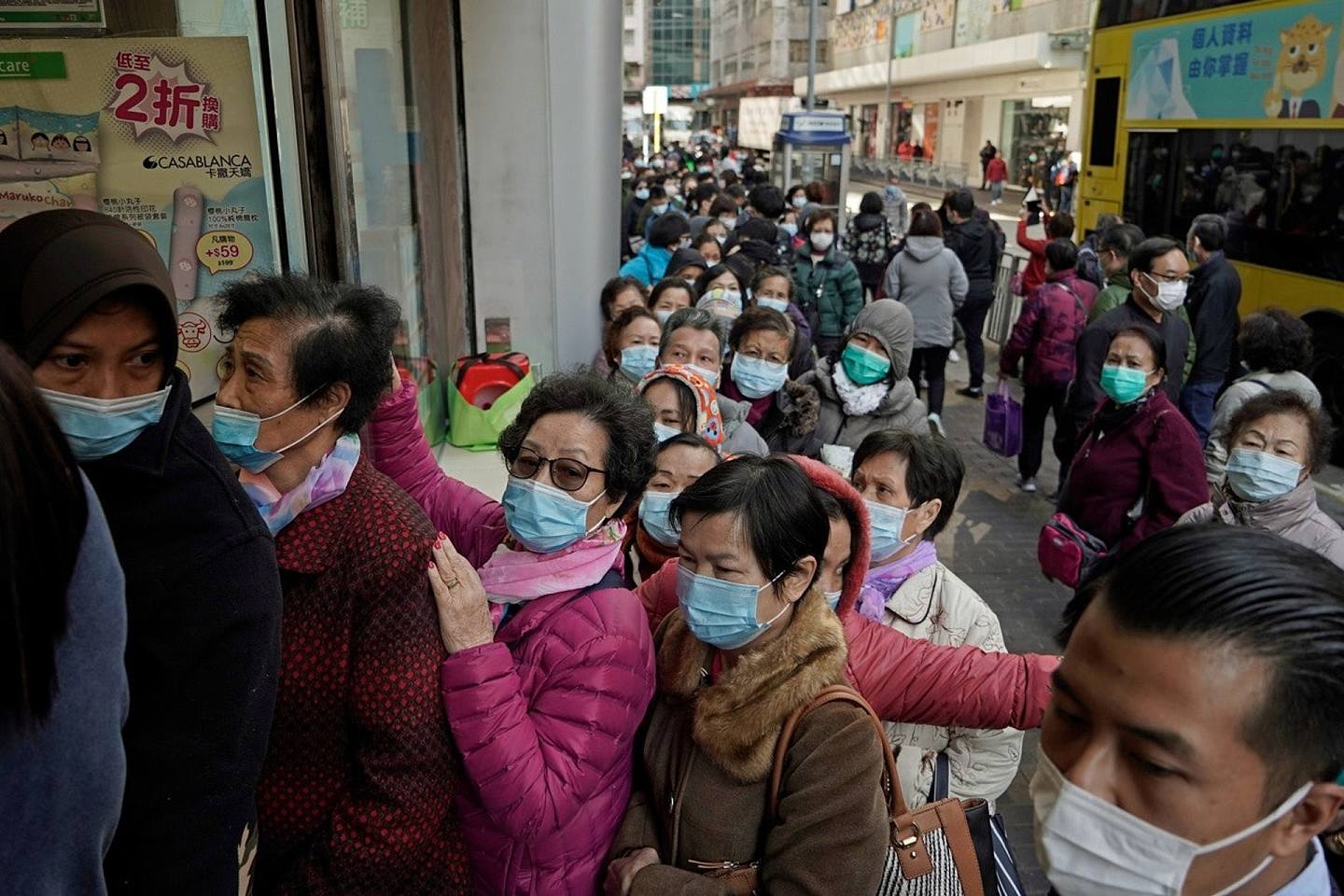 新冠肺炎疫情在香港蔓延。图为2020年1月30日，人们在香港的一家化妆品店排队购买口罩。（AP）