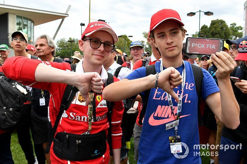 Spectators show their reaction to the news of the cancellation of the Grand Prix