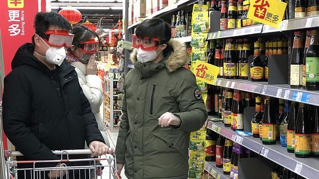 超市里戴口罩购物的消费者