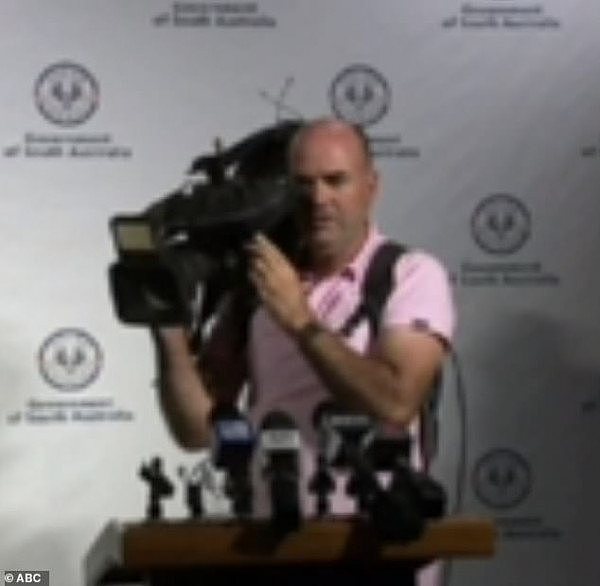 26283876-8141189-Cameraman_says_the_world_s_going_to_s_t_during_media_conference_-m-5_1584941246710.jpg,0