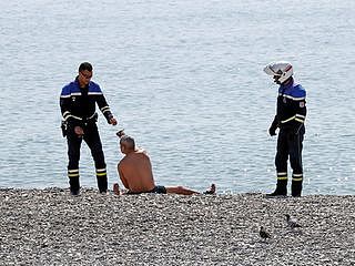 法国政府已经宣布禁止非必要外出，违者处于罚款。图为法国警察在海滩驱离外出民众。（Reuters）