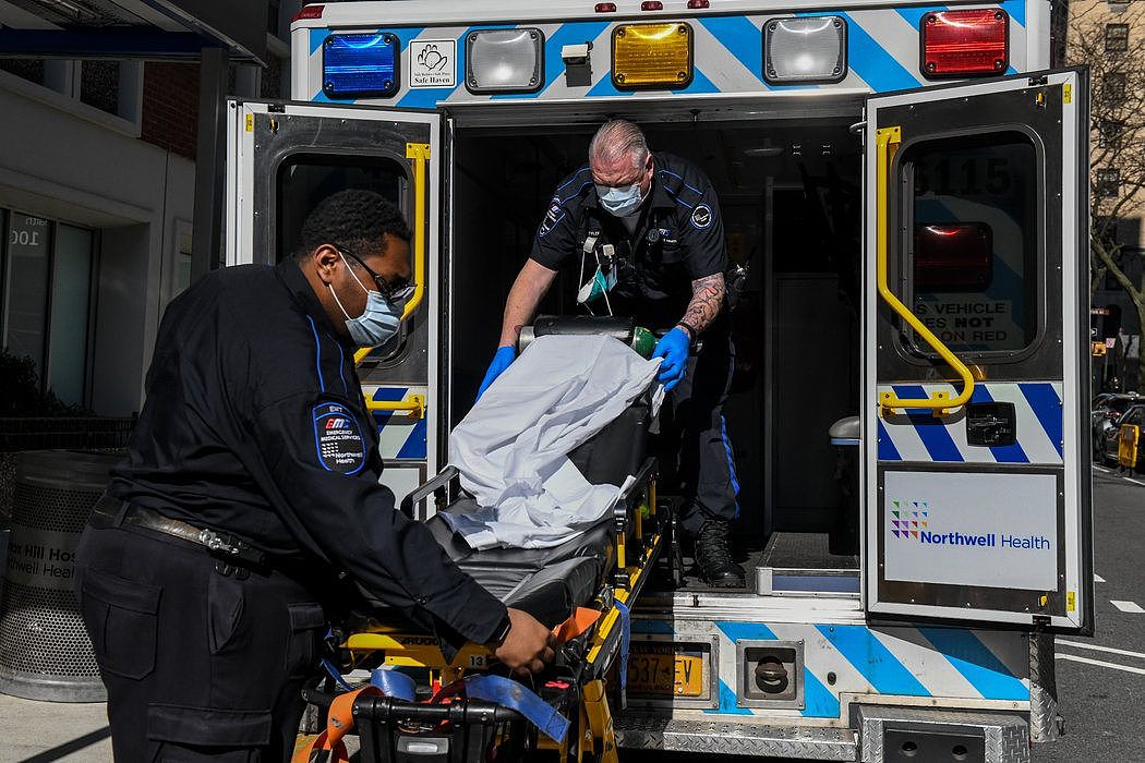 在周三将病人运送到纽约市的一家医院后，紧急医护人员更换担架上的被单。