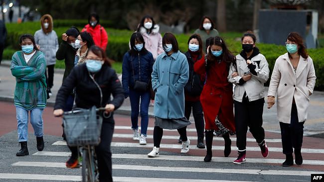 北京开始复工后，上班高峰期间的街头行人。(2020年3月26日)