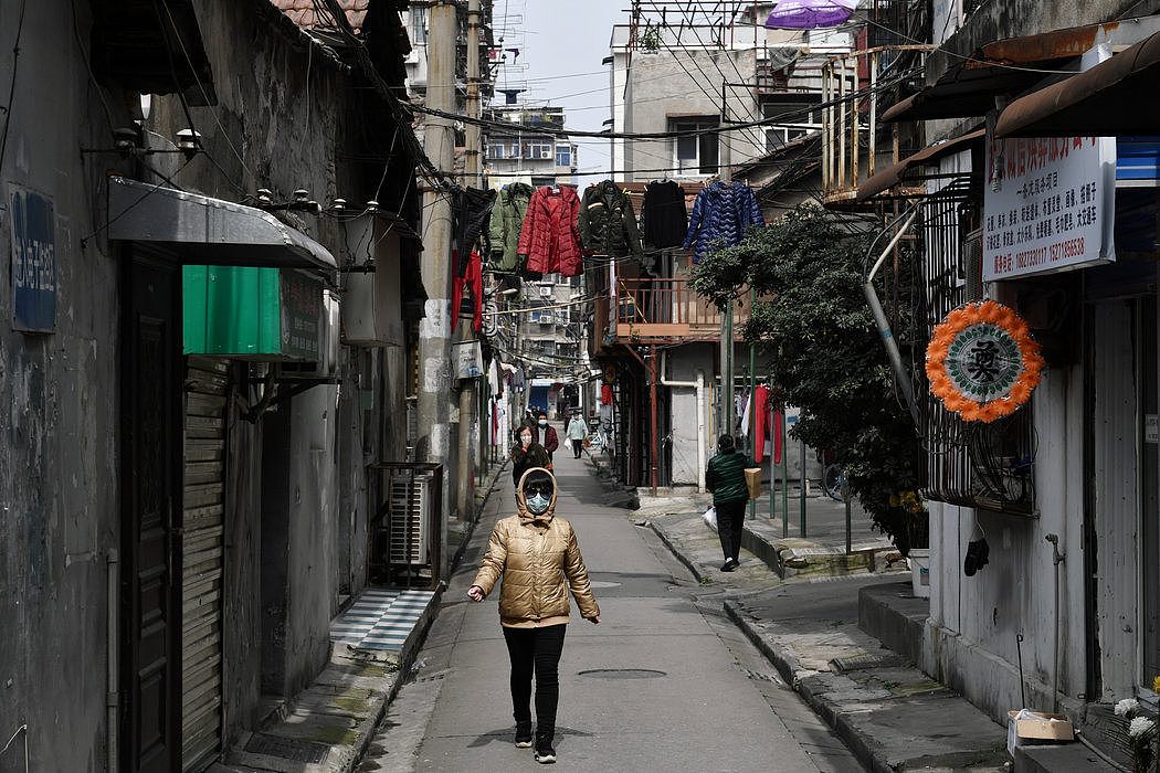 湖北武汉的一条小巷，如今路人都带上了口罩。