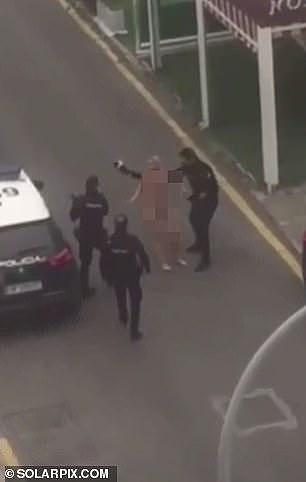 西班牙41岁女子不着衣衫爬上警车抗议，遭警棍惩戒，被拉上救护车