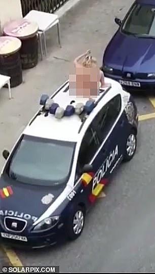 西班牙41岁女子不着衣衫爬上警车抗议，遭警棍惩戒，被拉上救护车