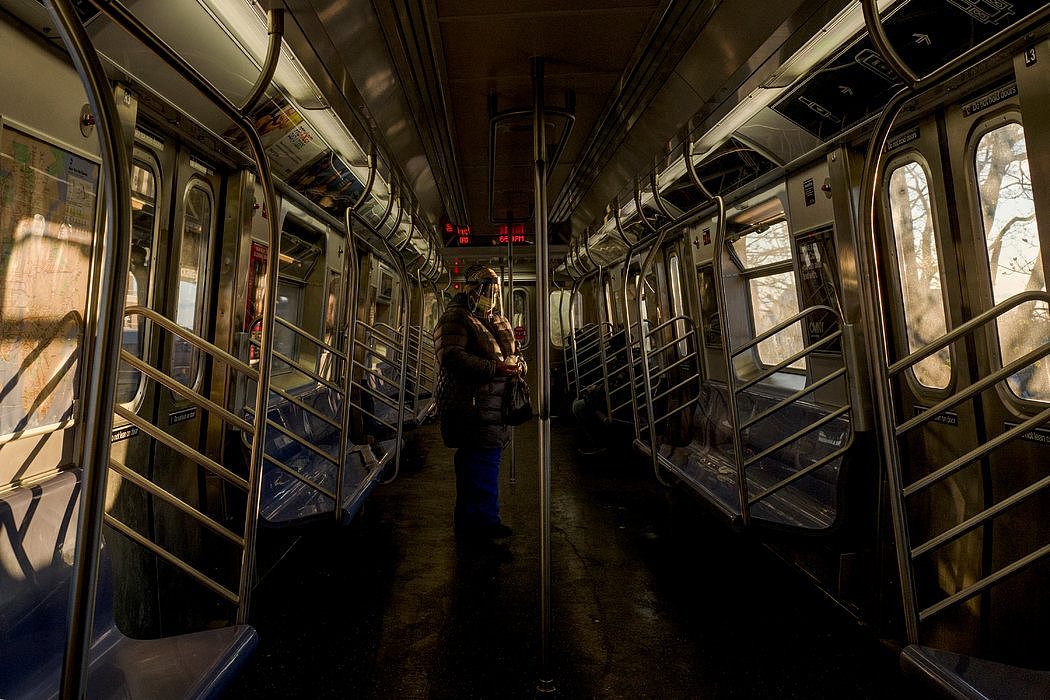 4月，纽约一辆空荡荡的地铁车厢里，一名穿着防护服的乘客。
