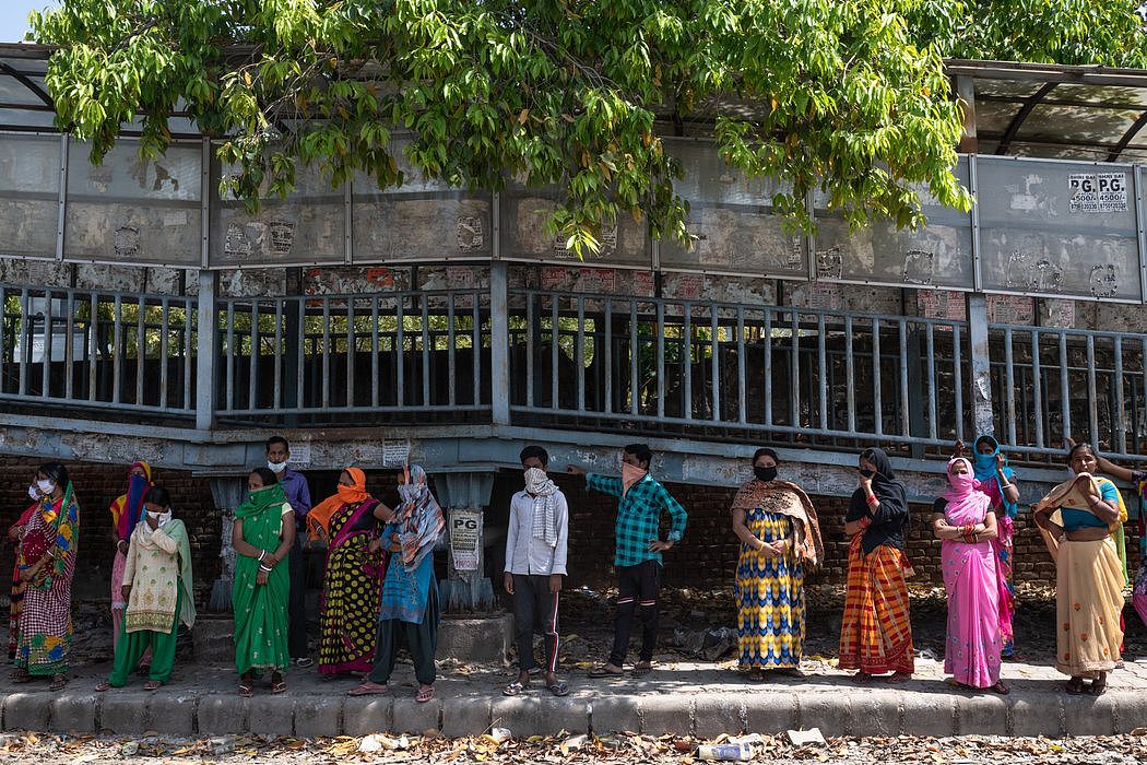 人们在新德里排队等候分发餐食。赚取日薪的工人的社会安全保障很少或者几乎没有，比起病毒的威胁，他们面临的饥饿的即刻威胁更大。