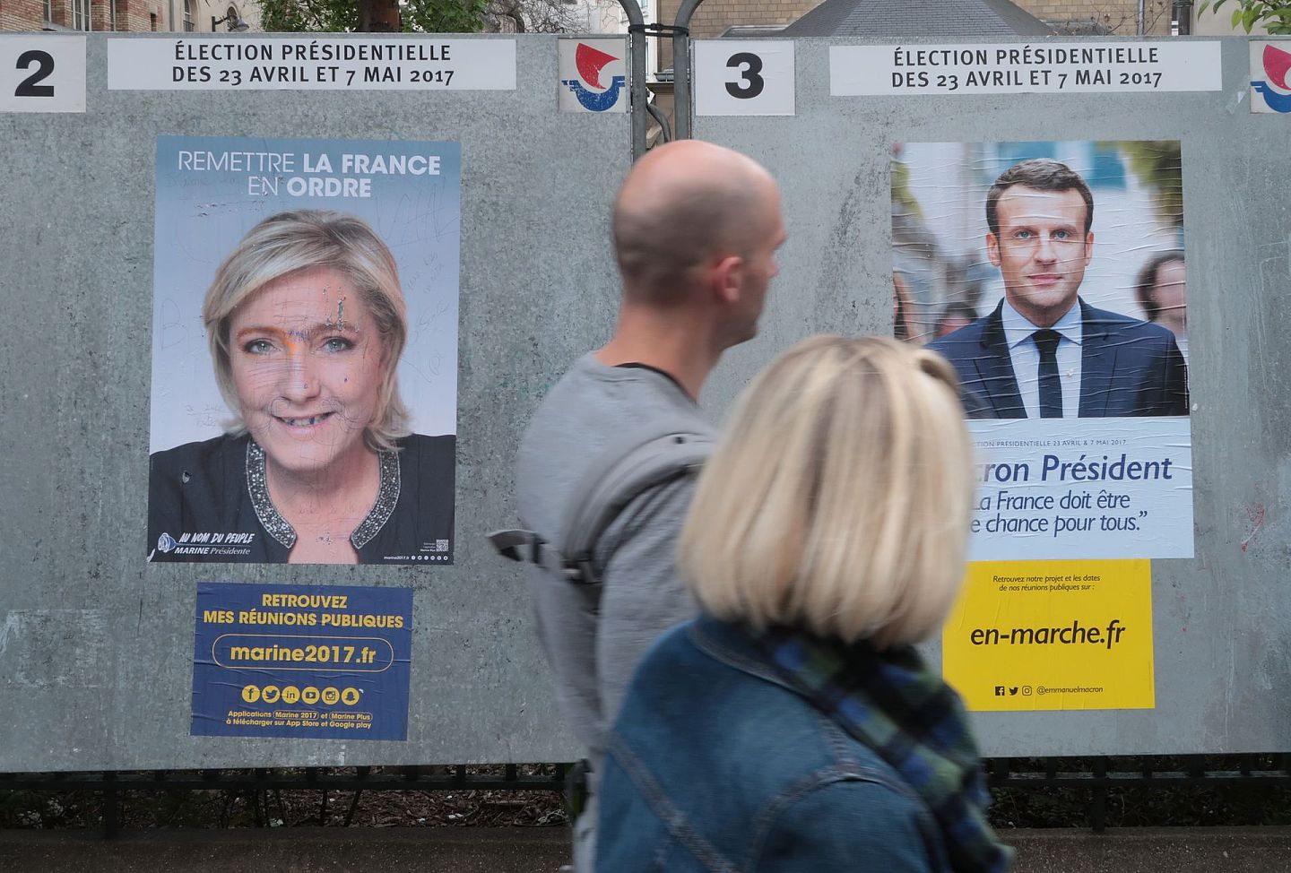 2017年4月10日，法国巴黎，人们走过展示总统候选人勒庞和马克龙的竞选海报。(Getty)